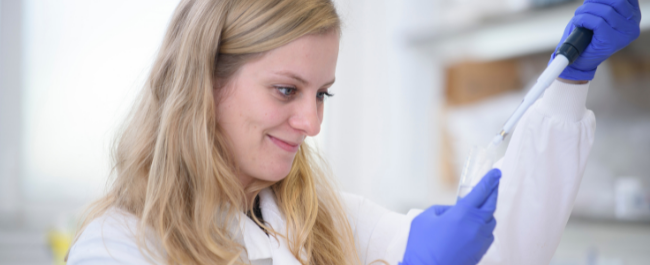 A University of Bristol researcher using large pipettes to undertake PhD research in a lab setting